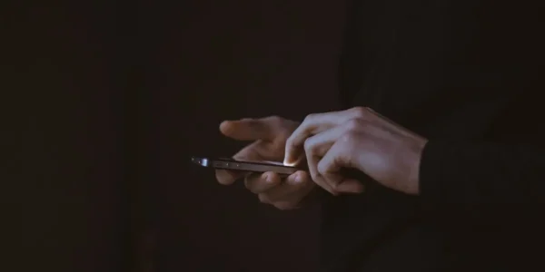 man holding phone playing pontoon online